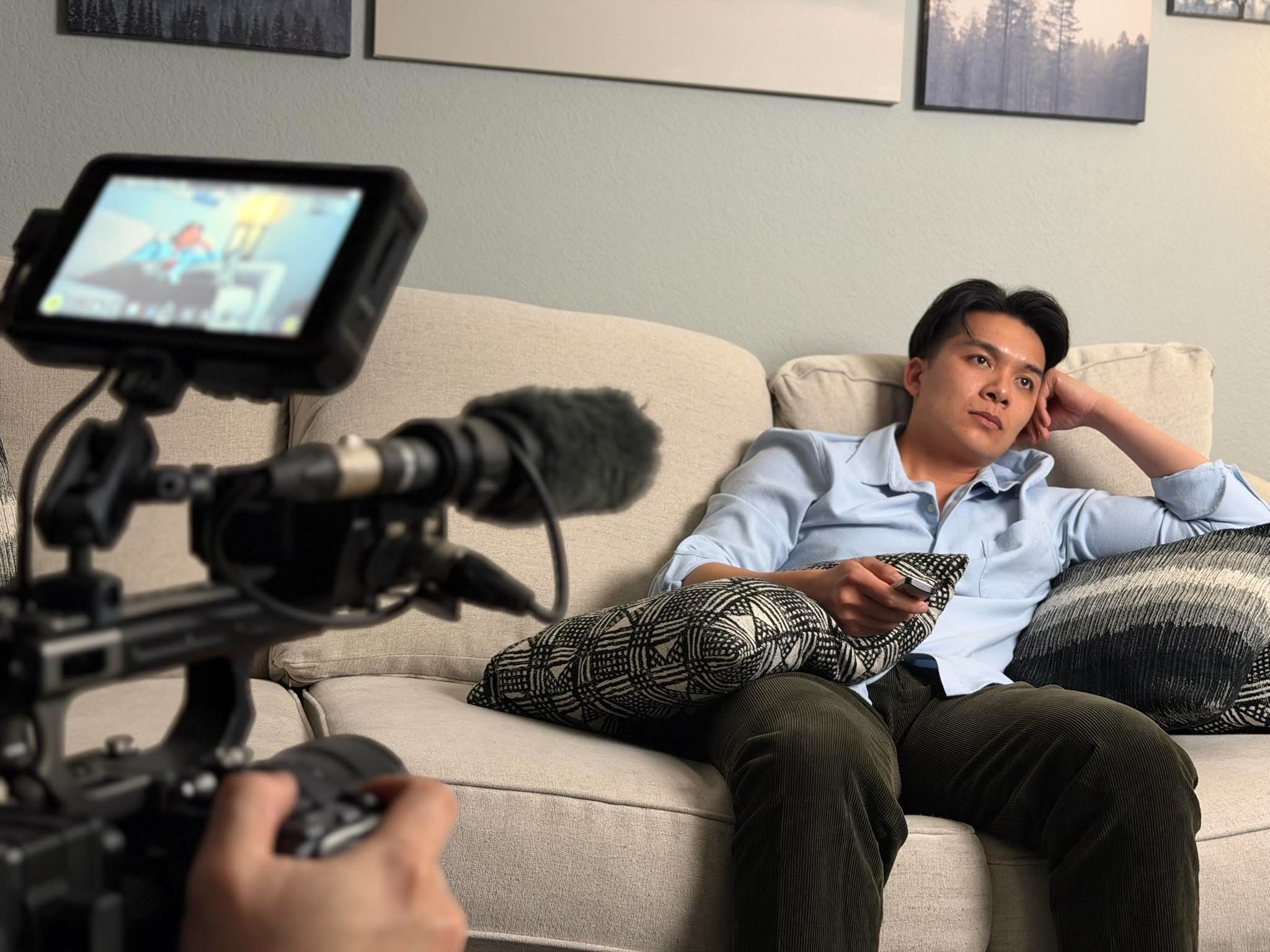 Thomas Tran in a lounge scene with camera and shotgun mic in frame