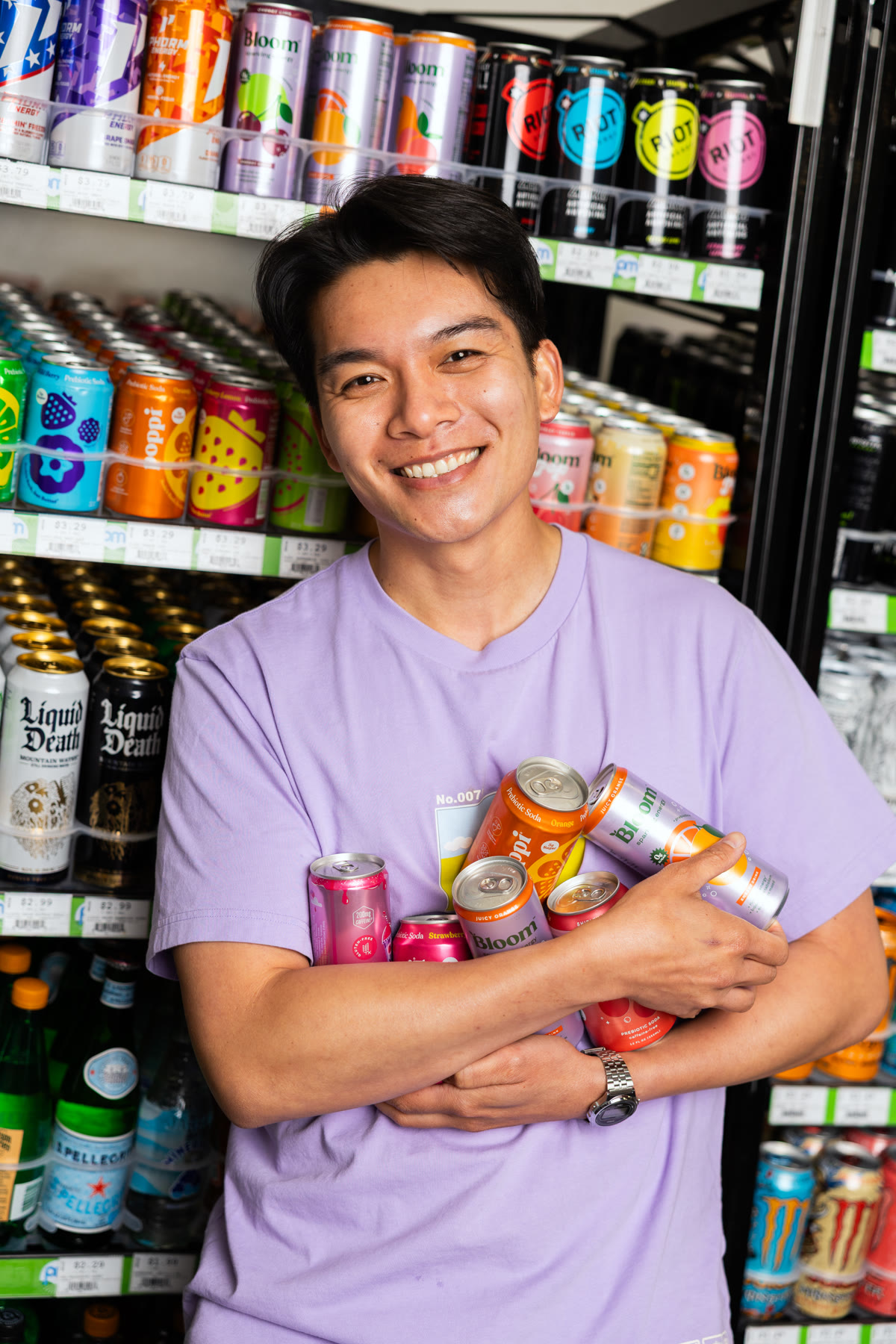 Thomas Tran smiling with an armful of drinks