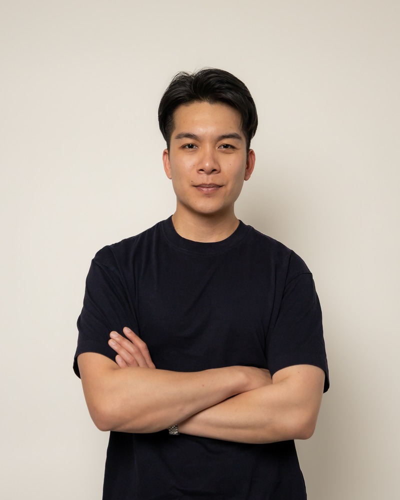 Thomas Tran – headshot, chest up, black tee, arms crossed
